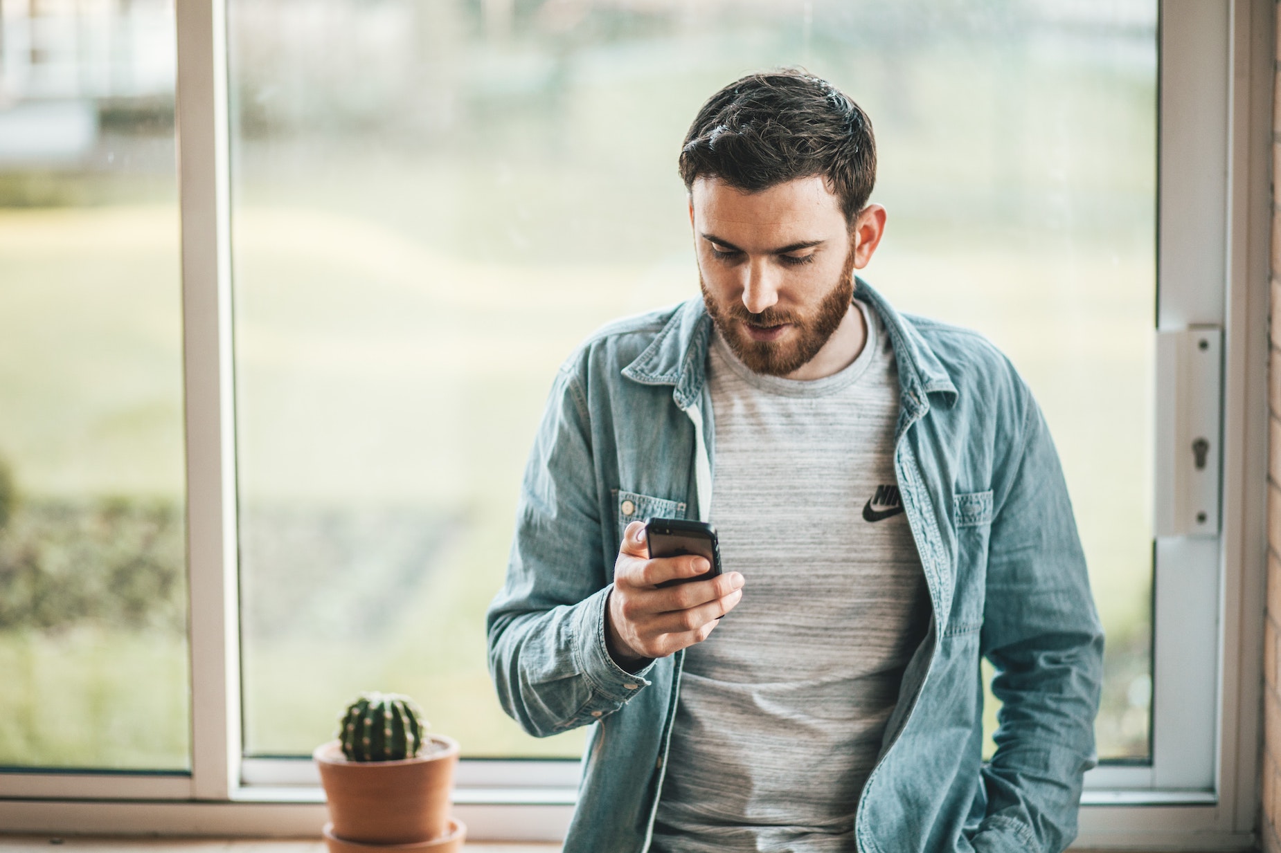 Man looking at his mobile phone after fraud text